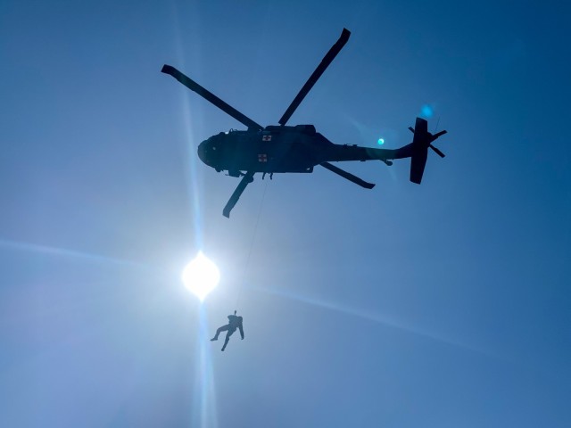 Staff Sgt. Jose Bulow, a flight medic with Golf Company, 1st Battalion, 168th Aviation Regiment (General Support Aviation Battalion), is hoisted into a UH-60 Black Hawk helicopter, March 26, 2021, at North Fort Hood, Texas, as part of training before a 9-month mission to the Middle East. Golf Company is attached to Task Force Phoenix, led by the California Army National Guard's 40th Combat Aviation Brigade. (U.S. Army National Guard photo by Staff Sgt. Tara Sawyer)