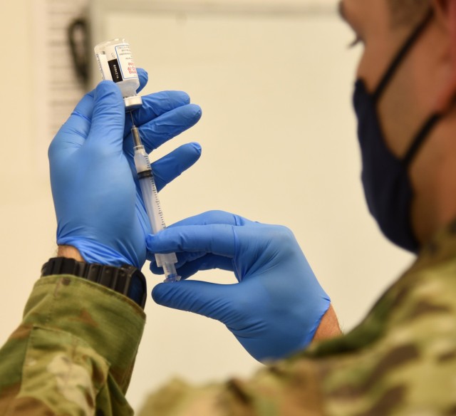 ASCII A Virginia National Guard Soldier prepares a COVID-19 vaccination March 10, 2021, at Fort Pickett, Virginia. The Virginia National Guard is reconfiguring the task force conducting COVID-19 testing and mask fit training to create mobile vaccination teams. (Photo by Mike Vrabel)