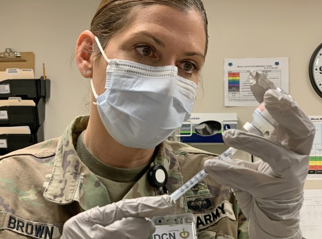 Maj. Jodi Brown, Chief of Public Health at the California Medical Detachment, prepares syringes for the paramedics administering the Moderna COVID-19 vaccine, March 23, 2021.