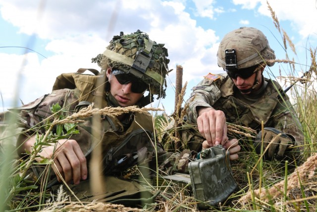 U.S. Army Staff Sgt. Robert Moore (right), with 1st Squadron, 2nd Cavalry Regiment, helps U.K. Army LT. Tom Chapman (left), assigned to the 1st The Queen's Dragoon Guards, set up M18A1 Claymore mine during a multinational claymore training exercise with Battle Group Poland at Bemowo Piskie Training Area, Poland on July 10, 2018. Battle Group Poland is a unique, multinational coalition of U.S., U.K., Croatian and Romanian Soldiers who serve with the Polish 15th Mechanized Brigade as a deterrence force in support of NATO’s Enhanced Forward Presence. (U.S. Army photo by Spc. Hubert D. Delany III /22nd Mobile Public Affairs Detachment)