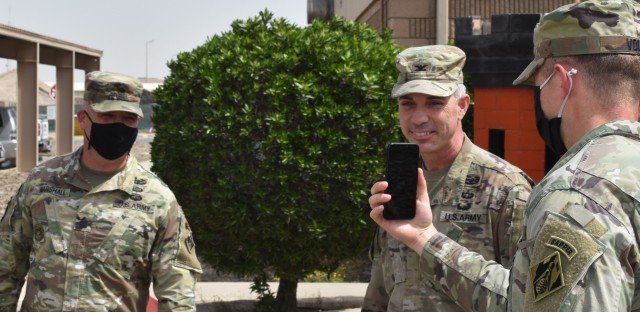 Col. Mark Geraldi smiles as he surprises his outgoing Sergeant Major, SGM Nathan Marshall with the virtual attendance of his family during his awards ceremony at Camp Arifjan, Kuwait. (Photo by Rick Benoit)