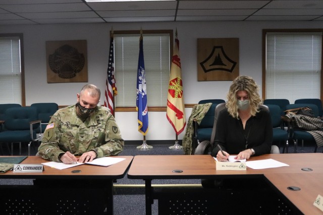 Garrison Commander Col. Michael Poss and Vernon County Administrator Cari Reddington sign an intergovernmental service agreement (IGSA) between the post and Vernon County on March 15, 2021, at Fort McCoy, Wis. The agreement involves line striping on roadways at Fort McCoy and is estimated to save the installation more than $166,000 over the next 10 years. It is the second IGSA the post has made in the last two years. (U.S. Army Photo by Scott T. Sturkol, Public Affairs Office, Fort McCoy, Wis.)