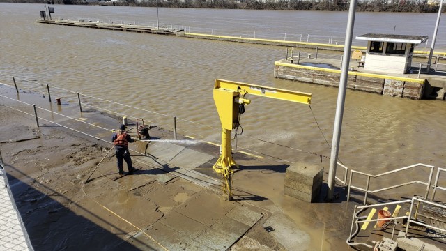 Even after flood waters have receded, crew members have to spray down mud and clear debris at the Locks and Dams 3 on the Monongahela River in Elizabeth, Pennsylvania, March 2, 2021. The cleanup can often take two weeks after a flood. High water from snow melts and extended rain affected the U.S. Army Corps of Engineers Pittsburgh District on the Monongahela River in early March. Elizabeth Locks and Dams (L/D 3) was taken out of service as water entered the operating machinery and topped the lock walls. The average time of high-water stopping operation was 30 hours. The lock staff cleared mud and debris, and each lock was returned to service within eight hours of water receding. Elizabeth is one of the oldest functioning locks in the nation, 114 years old. (U.S. Army Corps of Engineers Pittsburgh District Photo by Philip Delo)