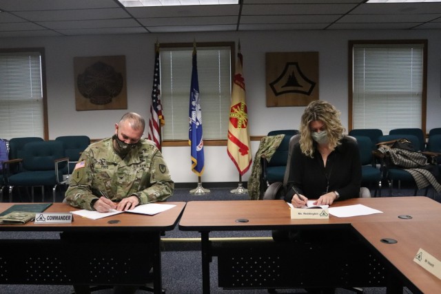 Garrison Commander Col. Michael Poss and Vernon County Administrator Cari Reddington sign an intergovernmental service agreement (IGSA) between the post and Vernon County on March 15, 2021, at Fort McCoy, Wis. The agreement involves line striping...
