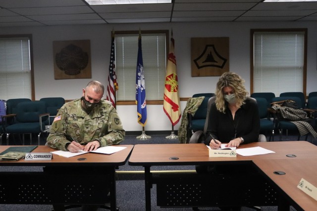 Garrison Commander Col. Michael Poss and Vernon County Administrator Cari Reddington sign an intergovernmental service agreement (IGSA) between the post and Vernon County on March 15, 2021, at Fort McCoy, Wis. The agreement involves line striping on roadways at Fort McCoy and is estimated to save the installation more than $166,000 over the next 10 years. It is the second IGSA the post has made in the last two years. (U.S. Army Photo by Scott T. Sturkol, Public Affairs Office, Fort McCoy, Wis.)