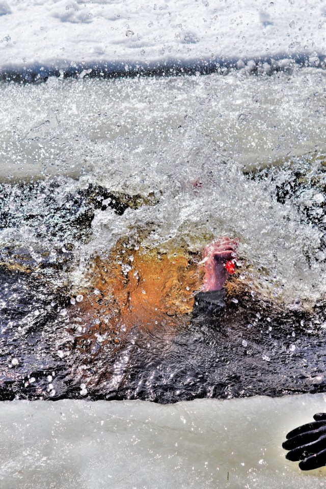 An Airman who is a student in Fort McCoy Cold-Weather Operations Course (CWOC) class 21-04 participates in cold-water immersion training Feb. 26, 2021, at Big Sandy Lake on South Post at Fort McCoy, Wis. CWOC students are trained on a variety of...
