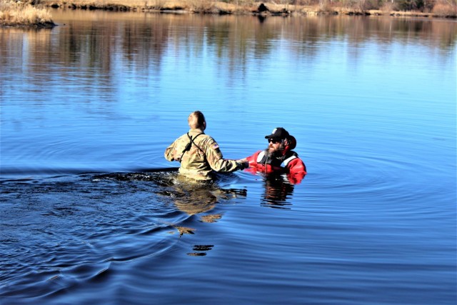 A student in Fort McCoy Cold-Weather Operations Course (CWOC) class 21-05 participates in cold-water immersion training March 19, 2021, at Big Sandy Lake on South Post at Fort McCoy, Wis. CWOC students are trained on a variety of cold-weather...