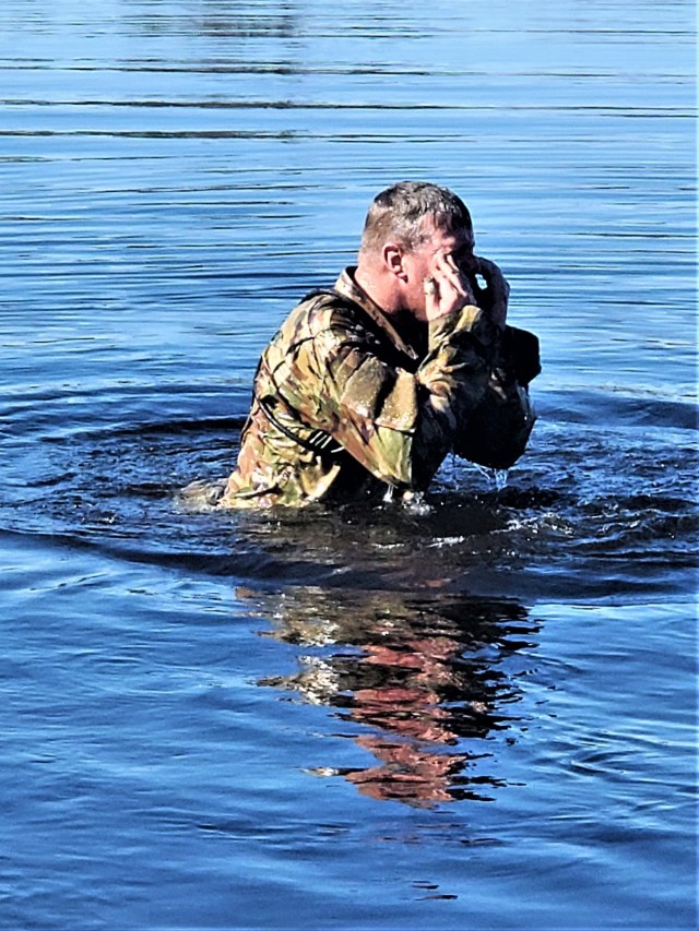A student in Fort McCoy Cold-Weather Operations Course (CWOC) class 21-05 participates in cold-water immersion training March 19, 2021, at Big Sandy Lake on South Post at Fort McCoy, Wis. CWOC students are trained on a variety of cold-weather...