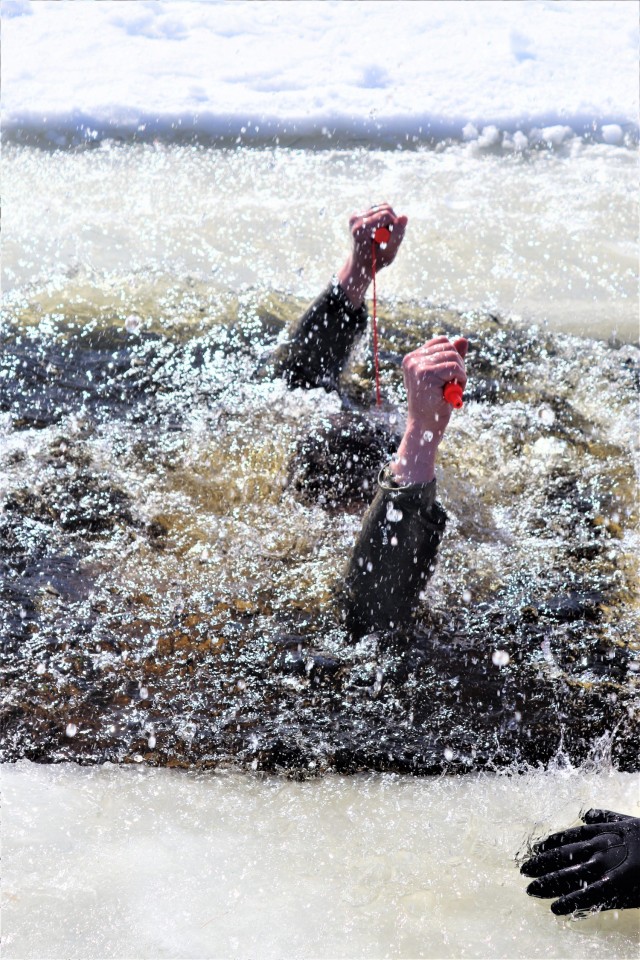 An Airman who is a student in Fort McCoy Cold-Weather Operations Course (CWOC) class 21-04 participates in cold-water immersion training Feb. 26, 2021, at Big Sandy Lake on South Post at Fort McCoy, Wis. CWOC students are trained on a variety of...