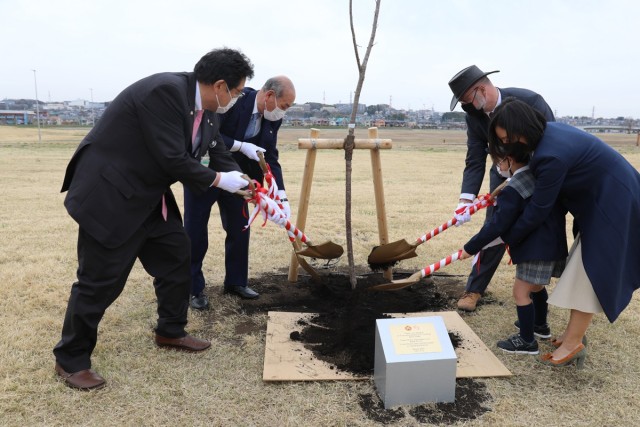 Representatives from Kanagawa City’s Chuo Ward, left, and U.S. Army Garrison Japan, right, plant a cherry blossom tree together March 25 on a shared area of Sagami General Depot to symbolize a commitment to the friendship between the...
