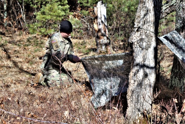 A student in Fort McCoy Cold-Weather Operations Course (CWOC) class 21-05 participates in shelter-building training March 11, 2021, at Fort McCoy, Wis. CWOC students are trained on a variety of cold-weather subjects, including snowshoe training...