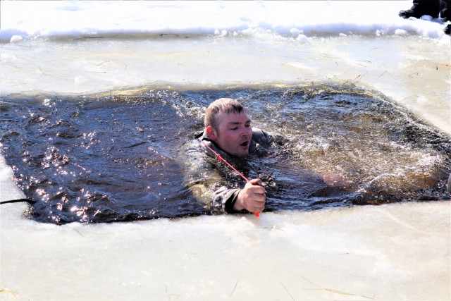 An Airman who is a student in Fort McCoy Cold-Weather Operations Course (CWOC) class 21-04 participates in cold-water immersion training Feb. 26, 2021, at Big Sandy Lake on South Post at Fort McCoy, Wis. CWOC students are trained on a variety of...