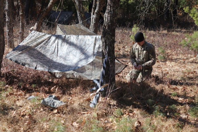 A student in Fort McCoy Cold-Weather Operations Course (CWOC) class 21-05 participates in shelter-building training March 11, 2021, at Fort McCoy, Wis. CWOC students are trained on a variety of cold-weather subjects, including snowshoe training...