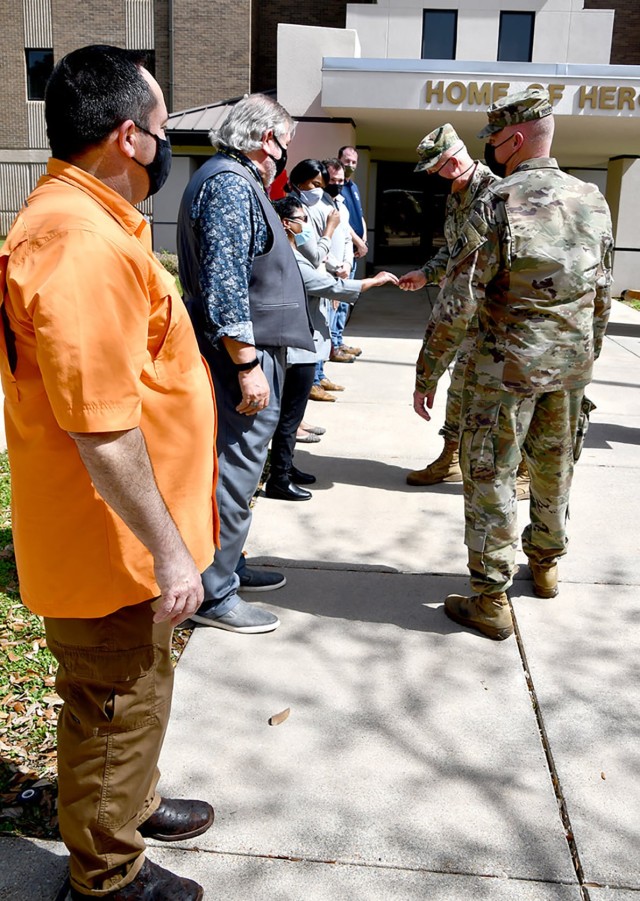 Maj. Gen. Timothy P. McGuire, IMCOM deputy commander, awards IMCOM coins to civilian workers during a visit to the Joint Readiness Training Center and Fort Polk March 23 as Col. Ryan K. Roseberry, Fort Polk garrison commander, looks on.