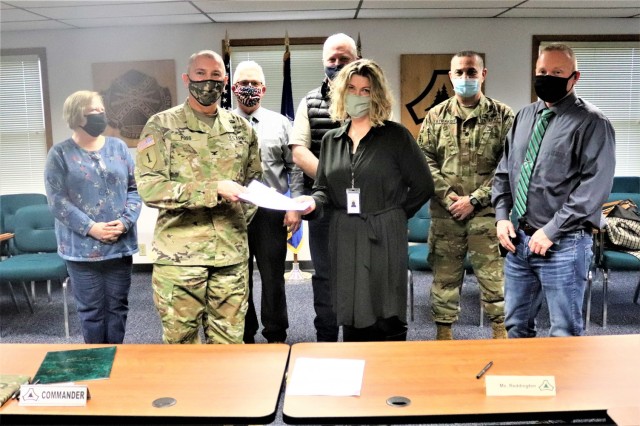 (From left) Fort McCoy Resource Management Officer Maureen Richardson, Garrison Commander Col. Michael Poss, Deputy to the Garrison Commander Brad Stewart, Vernon County Highway Commissioner Phil Hewitt, Vernon County Administrator Cari Reddington, Fort McCoy Staff Judge Advocate Lt. Col. Savas Kyriakidis, and Directorate of Public Works Operations and Maintenance Division Chief Nathan Sobojinski were all on hand for the signing of an intergovernmental service agreement (IGSA) between the post and Vernon County on March 15, 2021, at Fort McCoy, Wis. The agreement involves line striping on roadways at Fort McCoy and is estimated to save the installation more than $166,000 over the next 10 years. It is the second IGSA the post has made in the last two years. (U.S. Army Photo by Scott T. Sturkol, Public Affairs Office, Fort McCoy, Wis.)