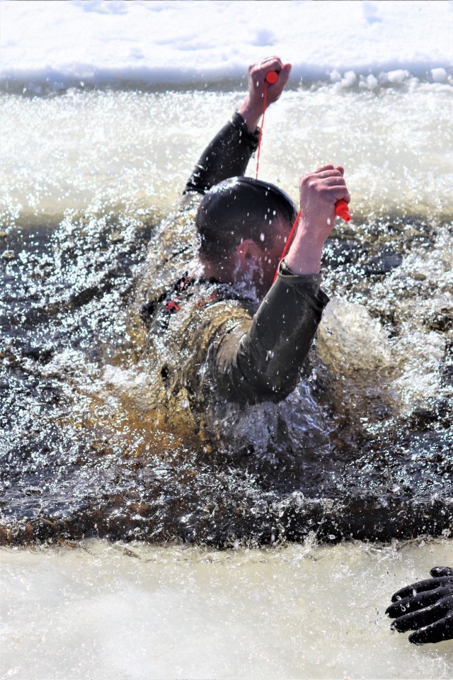 An Airman who is a student in Fort McCoy Cold-Weather Operations Course (CWOC) class 21-04 participates in cold-water immersion training Feb. 26, 2021, at Big Sandy Lake on South Post at Fort McCoy, Wis. CWOC students are trained on a variety of...