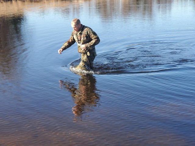 A student in Fort McCoy Cold-Weather Operations Course (CWOC) class 21-05 participates in cold-water immersion training March 19, 2021, at Big Sandy Lake on South Post at Fort McCoy, Wis. CWOC students are trained on a variety of cold-weather...