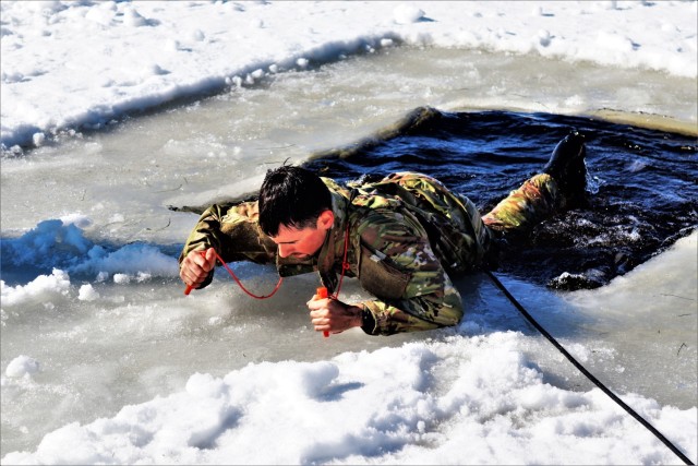 A student in the Fort McCoy Cold-Weather Operations Course (CWOC) class 21-04 participates in cold-water immersion training Feb. 26, 2021, at Big Sandy Lake on South Post at Fort McCoy, Wis. CWOC students are trained on a variety of cold-weather...