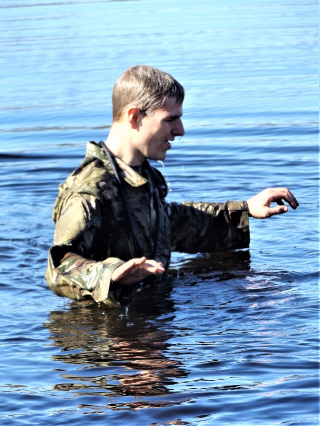 A student in Fort McCoy Cold-Weather Operations Course (CWOC) class 21-05 participates in cold-water immersion training March 19, 2021, at Big Sandy Lake on South Post at Fort McCoy, Wis. CWOC students are trained on a variety of cold-weather...