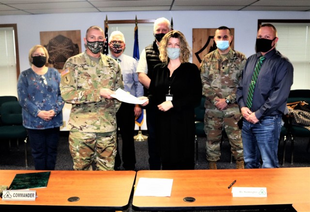 (From left) Fort McCoy Resource Management Officer Maureen Richardson, Garrison Commander Col. Michael Poss, Deputy to the Garrison Commander Brad Stewart, Vernon County Highway Commissioner Phil Hewitt, Vernon County Administrator Cari Reddington, Fort McCoy Staff Judge Advocate Lt. Col. Savas Kyriakidis, and Directorate of Public Works Operations and Maintenance Division Chief Nathan Sobojinski were all on hand for the signing of an intergovernmental service agreement (IGSA) between the post and Vernon County on March 15, 2021, at Fort McCoy, Wis. The agreement involves line striping on roadways at Fort McCoy and is estimated to save the installation more than $166,000 over the next 10 years. It is the second IGSA the post has made in the last two years. (U.S. Army Photo by Scott T. Sturkol, Public Affairs Office, Fort McCoy, Wis.)