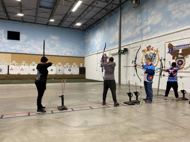 Maj. Adriana de Julio (left), Sgt. Brandon Jenkins (center left), Maj. Kyle Eldridge (center right) and veteran Mike Murphy (right) shoot at targets at the Archery School of the Rockies on March 11, 2021. Army Trials athlete de Julio competed in...