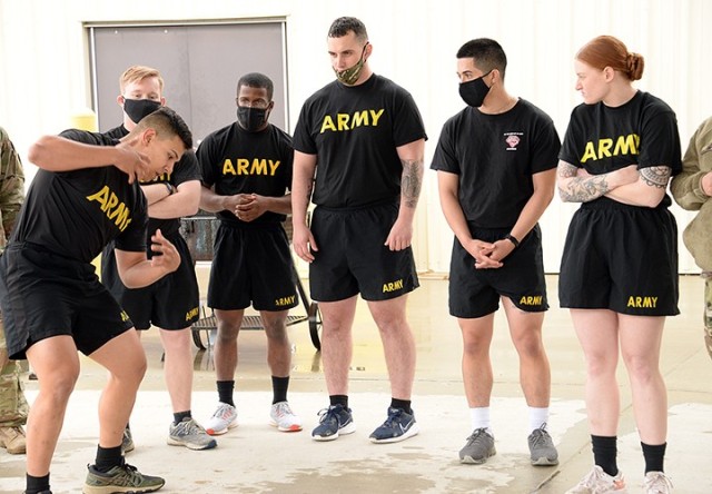 After completing the Iron Griffin gauntlet course, Sgt. Gilberto Garcia, 256th Military Police Company, 40th MP Battalion (Detention), offers advice about carrying the approximately 180-pound dummy to fellow competitors — Spc. Howard Post, Headquarters and Headquarters Company, Joint Regional Correctional Facility; Pfc. Elijah Nash, 526th MP Company, 40th; Spc. Ryan Fisher, 291st MP Company, 40th; Sgt. Alberto Alfaro, 165th MP Company, 705th; and Sgt. Shayla Taylor, 165th MP Company, 705th — during the 15th MP Brigade's NCO and Soldier of the Year competition March 25 outside the battalions' company operations facilities. Garcia and Nash were named NCO and Soldier of the Year for the 40th MP Battalion, and Alfaro and Pfc. Jason Geise, 165th MP Company, were named NCO and Soldier of the Year for the 705th MP Battalion. Photo by Prudence Siebert/Fort Leavenworth Lamp