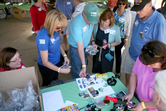 Kerrie Branson, Survivor Outreach Services coordinator for Redstone Arsenal, Alabama, left in the blue shirt, helps Gold Star Families create buttons of their loved ones during a U.S. Army Space and Missile Defense Command-sponsored Spring Fling...