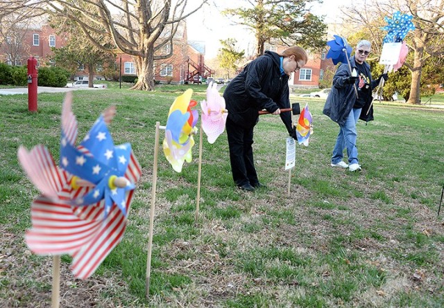 Tricia Green, domestic violence victim advocate, and Jayne Meath, Family Advocacy Program specialist, arrange pinwheels on the front lawn of the Resiliency Center for a Pinwheels for Prevention pinwheel garden March 31. April is Child Abuse...