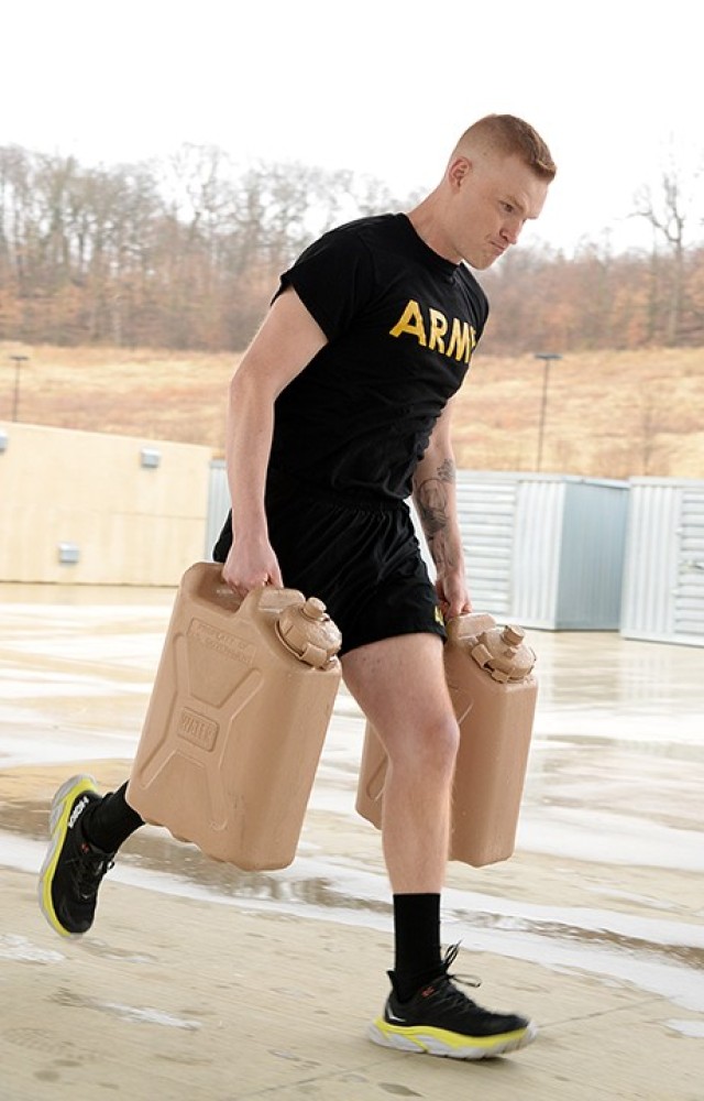Pfc. Jason Geise, 165th Military Police Company, 705th MP Battalion (Detention), runs 100 meters carrying water jugs in the Iron Griffin gauntlet course, which also included 100-meter iterations of a dummy carry, bear crawl and sprint, during the 15th MP Brigade NCO and Soldier of the Year competition March 25 outside the company operations facilities. Geise was named Soldier of the Year for the 705th MP Battalion and will go on to represent Fort Leavenworth in the Combined Arms Center competition. Photo by Prudence Siebert/Fort Leavenworth Lamp
