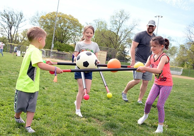 Dad Loren Schmidt watches 4-year-old Riley, 9-year-old Evelyn and 6-year-old Danica balance sports balls as they make their way toward a relay finish line where mom Air National Guard Maj. Angie Schmidt, Command and General Staff Officer Course student, and 2-year-old Madelyn wait during the Family Fun Inflatable Challenge April 27, 2019, at Doniphan Field. April is Month of the Military Child. File photo by Prudence Siebert/Fort Leavenworth Lamp