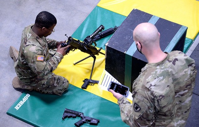 Pfc. Elijah Nash, 526th MP Company, 40th MP Battalion (Detention), assembles and performs function checks on an M4, M9 and M249 under the watch of grader Staff Sgt. Bobby Regan, Headquarters and Headquarters Company, 40th Military Police Battalion (Detention) during the soldier tasks portion of the 15th MP Brigade NCO and Soldier of the Year competition March 24 in the company operations facility. Nash was named Soldier of the Year for the 40th MP Battalion and will go on to represent Fort Leavenworth in the Combined Arms Center competition. Photo by Prudence Siebert/Fort Leavenworth Lamp