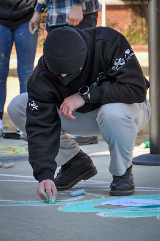 CAMP HUMPHREYS, Republic of Korea - Spc. Ian Holmes, the Humphreys Better Opportunities for Single Soldiers (BOSS) President and a CH-47 helicopter repairer assigned to Installation Management Command, helps draw the BOSS logo created as part of...