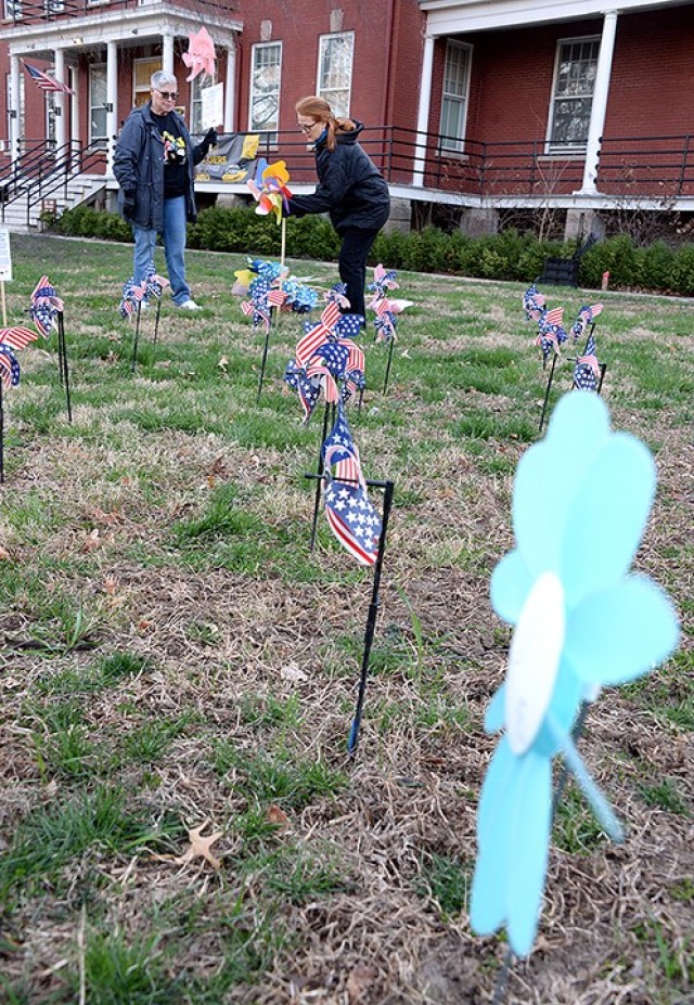Jayne Meath, Family Advocacy Program specialist, and Tricia Green, domestic violence victim advocate, arrange pinwheels on the front lawn of the Resiliency Center for a Pinwheels for Prevention pinwheel garden March 31. April is Child Abuse...
