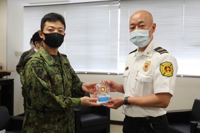 Nobuki Azuma, right, assigned to the U.S. Army Garrison Japan Directorate Emergency Services, poses with a plaque he received from Col. Kazuya Ono, left, commander of the JGSDF’s 4th Engineer Group and JGSDF Camp Zama during a March 30 ceremony...