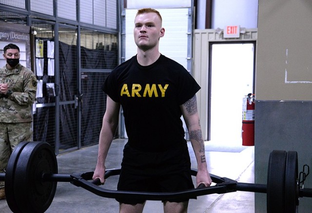 Pfc. Jason Geise, 165th Military Police Company, 705th MP Battalion (Detention), performs 19 repetitions lifting 195 pounds in the Iron Griffin fitness challenge during the 15th MP Brigade NCO and Soldier of the Year competition March 25 in the company operations facility. Geise was named Soldier of the Year for the 705th MP Battalion and will go on to represent Fort Leavenworth in the Combined Arms Center competition. Photo by Prudence Siebert/Fort Leavenworth Lamp