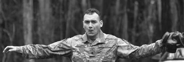 Spc. Arturo Gutierrez Jr., 217th Military Police Detachment, raises arms to facilitate breathing after spending time in the gas chamber during training April 1 at the range training complex.