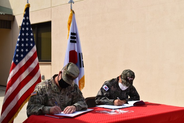 Col. Garrett Cottrell (left), Deputy Commanding Officer - Transformation, U.S. Army Corps of Engineers Far East District, and Col. Pyo In Tae (right), Chief, Program Management Team, ROK Design and Construction Agent, sign the Acceptance Release...