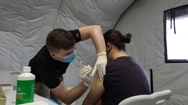 SAIPAN, Northern Mariana Islands (April 3, 2021) – Sgt. Jarrod Clements, assigned to 25th Infantry Division, administers a COVID-19 Vaccine in support of the Commonwealth Healthcare Corporation (CHCC) COVID-19 Vaccination team at the Medical Care and Treatment Site (MCATS). U.S. Indo-Pacific Command, through U.S. Army Pacific, remains committed to providing continued, flexible Department of Defense support to the Federal Emergency Management Agency as part of the whole-of-government response to COVID-19. (U.S. Navy photo by Brad Ruszala)