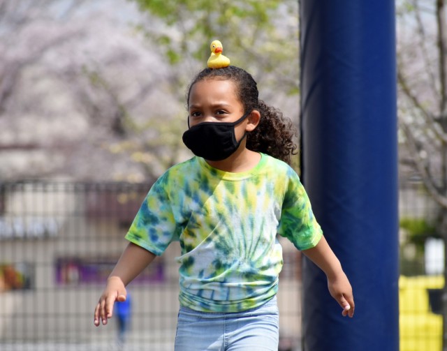 Analisa Myrtil, a first-grader, participates in the 2021 School Age Center Olympics at Sagamihara Family Housing Area, Japan, April 1, by balancing a rubber duck on her head while walking.
