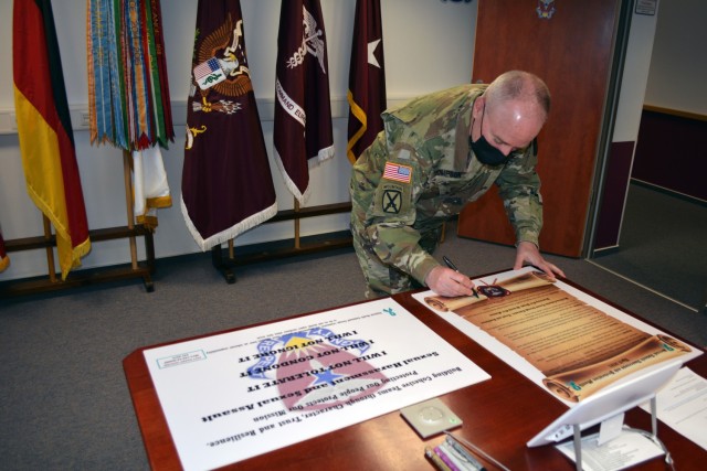 Brig. Gen. Mark Thompson, commanding general for Regional Health Command Europe, signs a proclamation that RHCE recognizes April as Sexual Assault Awareness and Prevention Month.