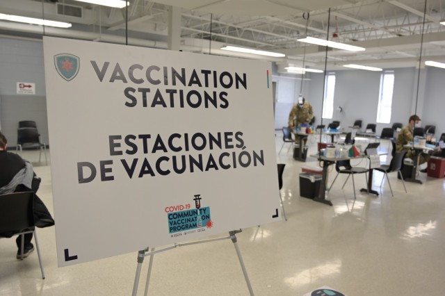 COVID-19 vaccination sign sits in the athletics building on Triton College in Des Plaines, Illinois, February 27, 2021. This sign is one of many designed to help Cook County, Illinois citizens navigate the vaccination-visit process. (U.S. Air Force photo by Staff Sgt. Aaron Rodriguez, Illinois National Guard)