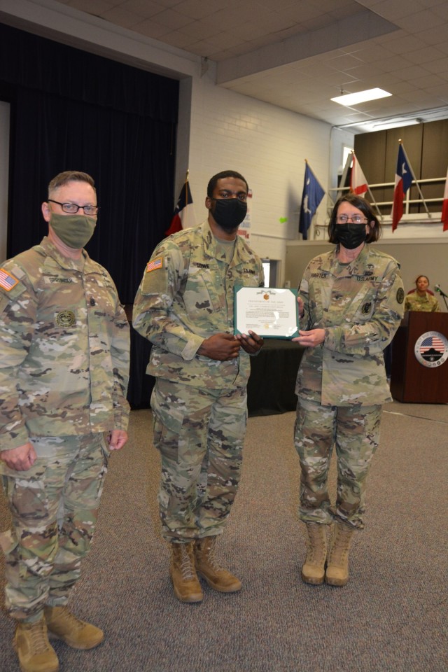 Cpl. Larry Lowe, Jr. (center), the Fort Irwin Dental Clinic 1 noncommissioned officer in charge, receives an Army commendation medal March 29 at Joint Base San Antonio, Texas for winning the Regional Dental Command-Central’s NCO of the Year...