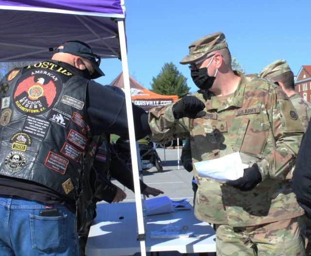 A member of the American Legion Riders elbow bumps a 1st Theater Sustainment Command Soldier at the safety stand down here, April 2, 2021. The riders are members of the Elizabethtown American Legion Post 113, and they sponsored the motorcycle...