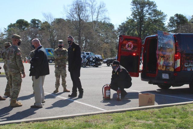 Firefighters from the Fort Knox Fire Department demonstrate how to use a fire extinguisher during  the 1st Theater Sustainment Command safety stand down, April 2, 2021 in front of the headquarters building at Fort Knox, Kentucky. They also discussed safe grilling techniques as barbeque season begins.
