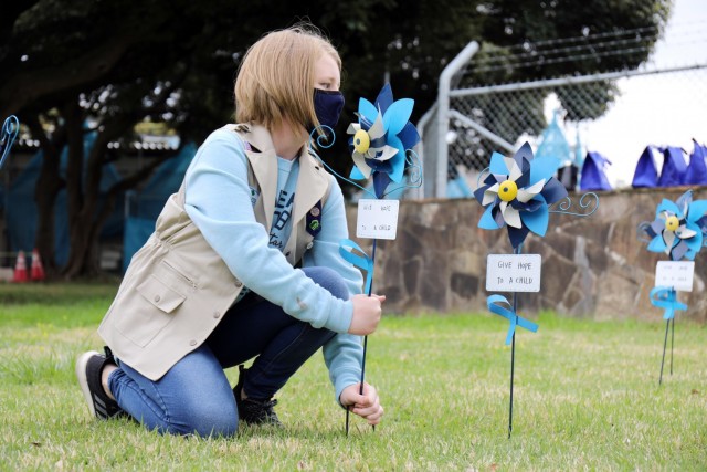 Kaitlyn Dodson, 12, a member of Girl Scout Troop 600, plants a pinwheel in honor of National Child Abuse Prevention Month at Camp Zama, Japan, April 6.