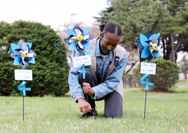 Naomi Thomas, 14, a member of Girl Scout Troop 600, plants a pinwheel in honor of National Child Abuse Prevention Month at Camp Zama, Japan, April 6.