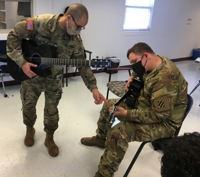 Spc. Jonathan Rodriquez teaching Cpl William Cody Liscomb during a lesson as part of the Adaptive Reconditioning Program. . The 3rd Infantry Division Band provides volunteers to assist with an eight-week long Adaptive Reconditioning Program to teach guitar as part of recreational therapy. Photo by Sgt. Anthony Licata 
