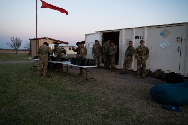Crew chiefs and pilots from C Company, 1st Assault Helicopter Battalion, 140th Aviation Regiment, Washington National Guard, load ammo cans to assist in aerial gunnery at Fort Sill, Oklahoma, March 30, 2021.