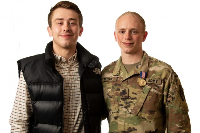 Senior Airman Kelvin Yde and Spc. Justice McBain pose for a photo after the Soldier’s Medal presentation ceremony for McBain April 11, 2021, at Milwaukee, Wisconsin. (U.S. Army Reserve photo by Maj. Jeku Arce) (This photo has been altered by extending the white backdrop evenly throughout the frame.)