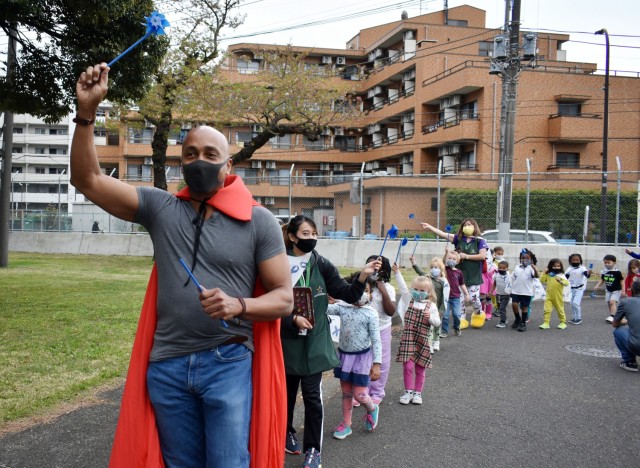 Darren Powell, Army Community Service Family Advocacy Program specialist, leads children on a superhero parade at the Child Development Center at the Sagamihara Family Housing Area, Japan, April 9. Camp Zama Family and Morale, Welfare and...